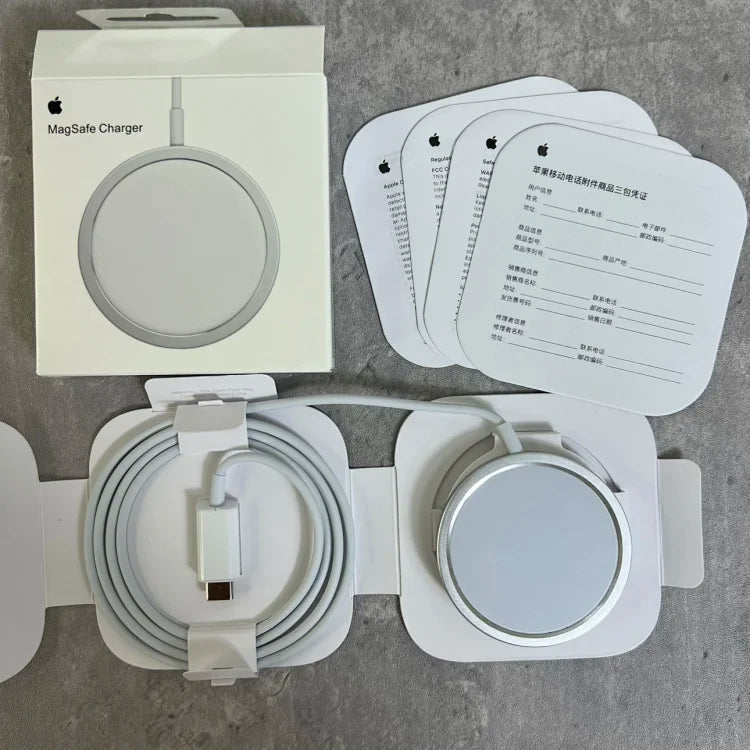 White Apple MagSafe Charger with circular magnetic disc, USB-C cable, documentation cards, and retail packaging displayed on