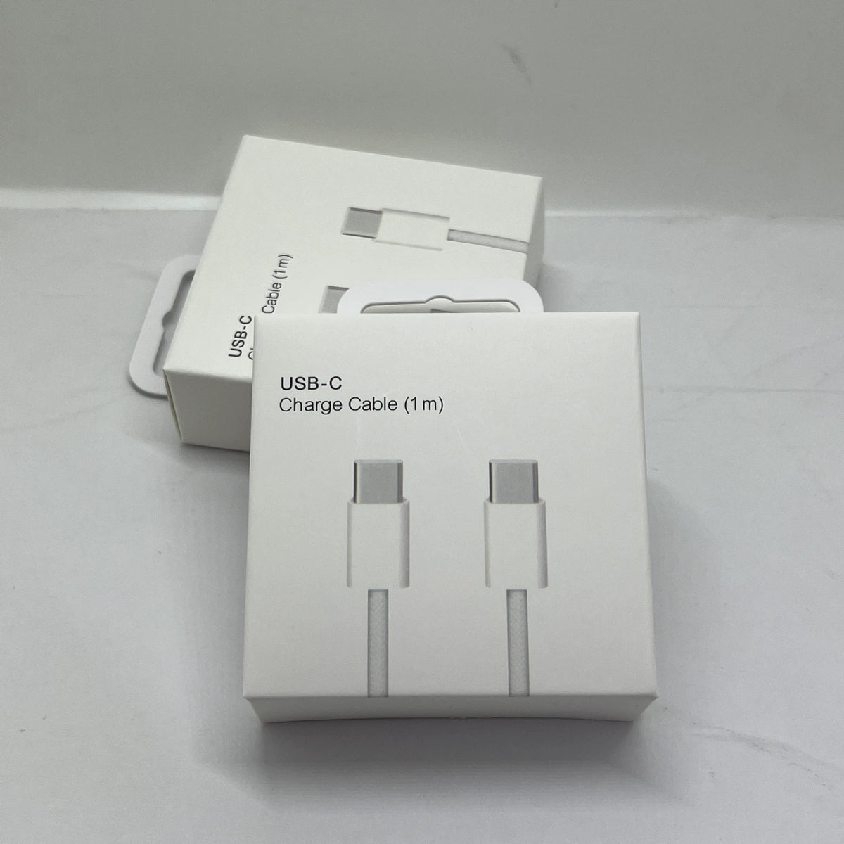 Two white USB-C charging cables in their retail packaging, displayed with one box open showing the coiled cable connectors