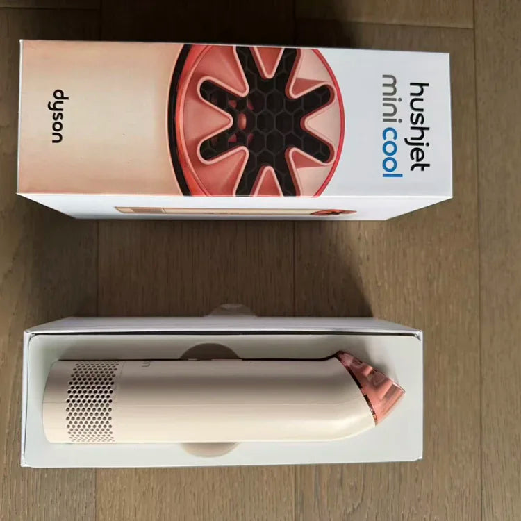 White cylindrical device with perforated metal section and rose gold/copper angled attachment, displayed in open product box