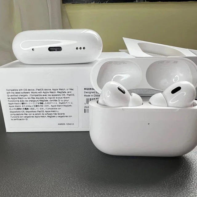 White Apple AirPods Pro with charging case open, displaying two earbuds inside, alongside documentation card on gray surface.