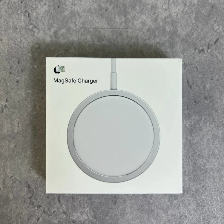 White box containing a silver-rimmed circular wireless charging pad with attached cable, displayed against concrete